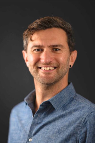 Stuart Avery is a white man with dark hair smiling into the camera